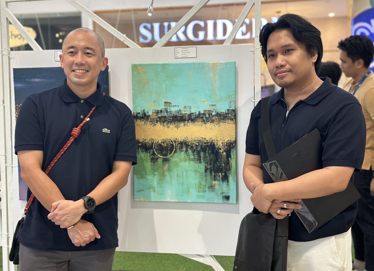SM Supermalls’ regional operations manager Jesse Herrera (left) with artist Jose Antonio Japitana and his artwork.
